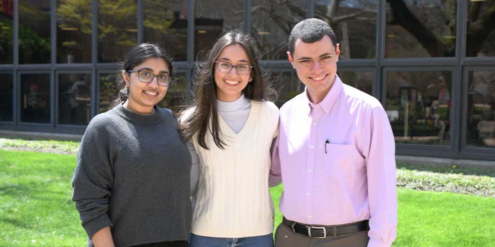 Three undergraduate research award winners standing together in front of the campus center